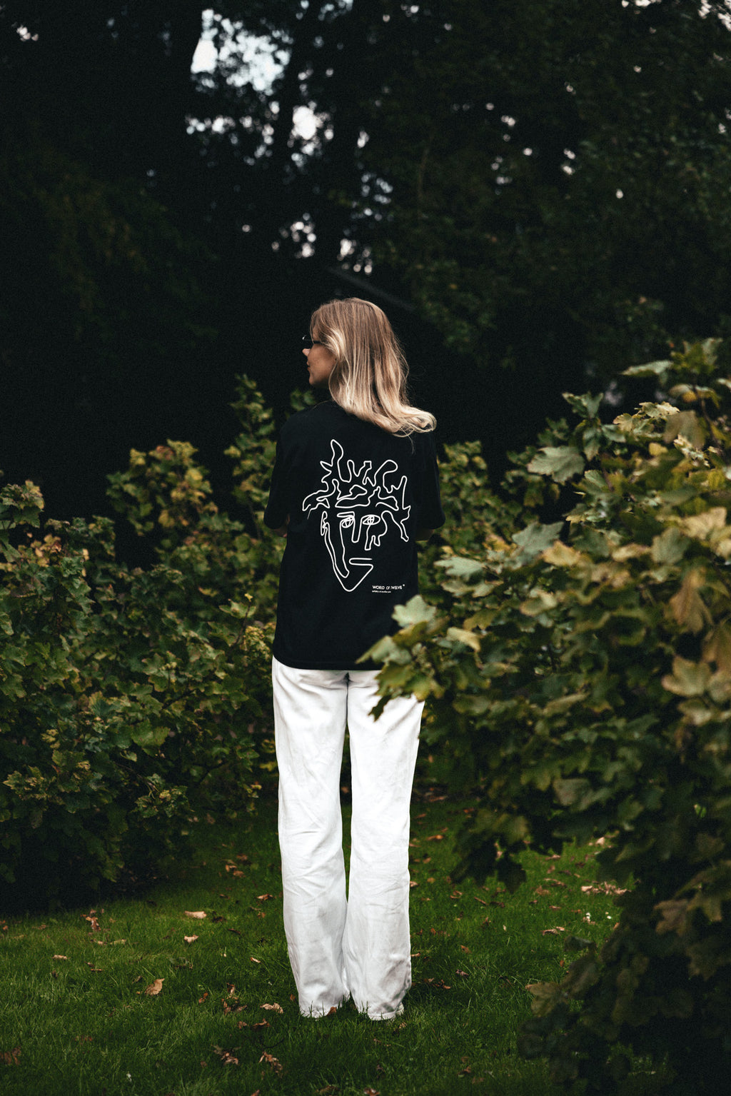 Woman wearing the Visage oversized tee in black, back view