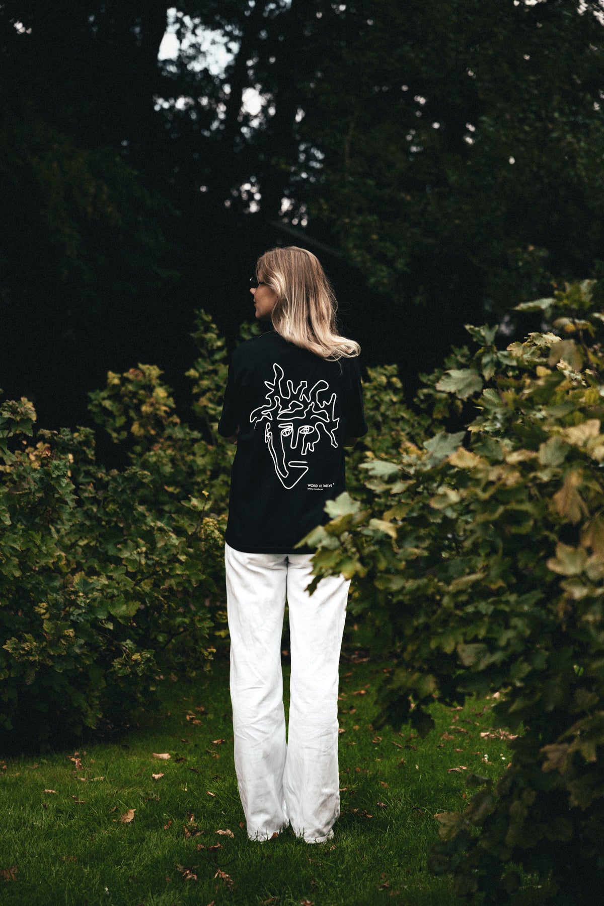 Woman wearing the Visage oversized tee in black, back view